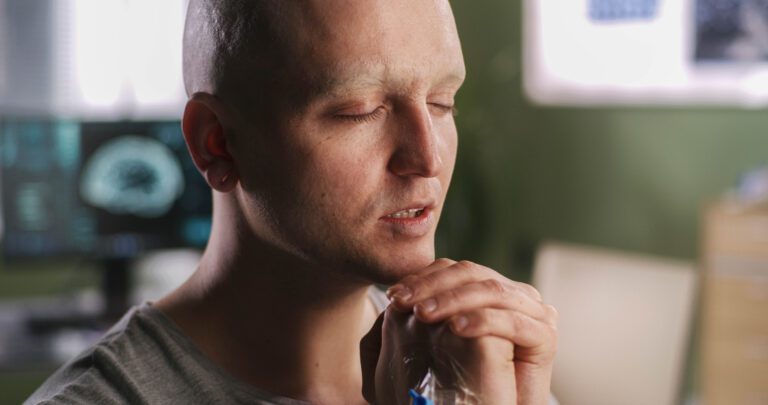 A Bald Man Deep in Thought, Hand Resting On His Face.